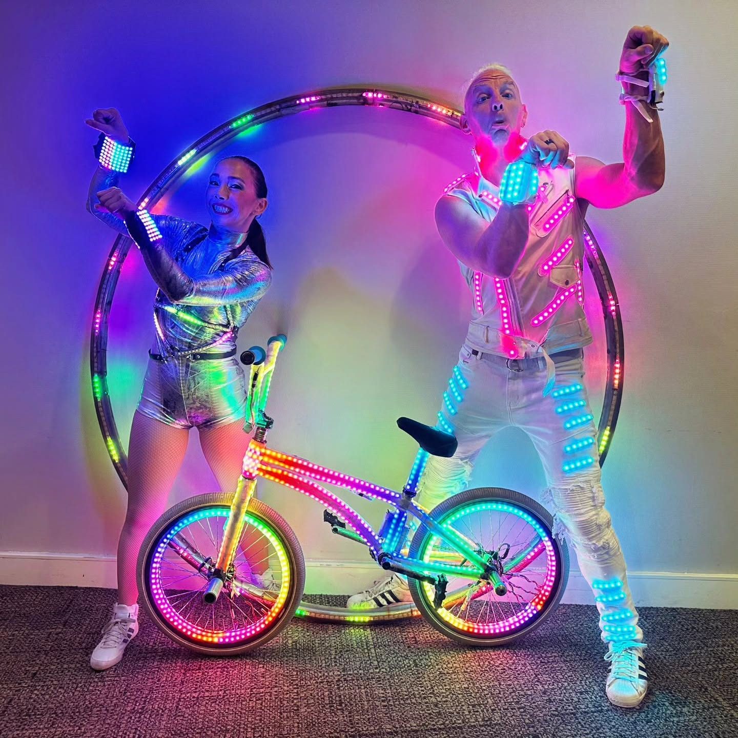 Blake Hicks with an LED hoop performer and rainbow LED bike