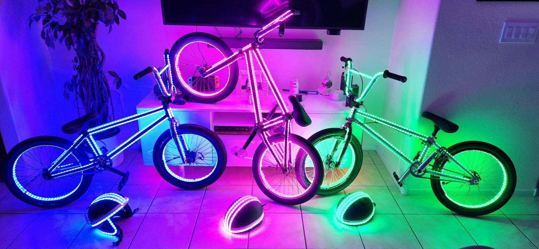 Three custom LED bikes and LED helmets in blue, pink and green