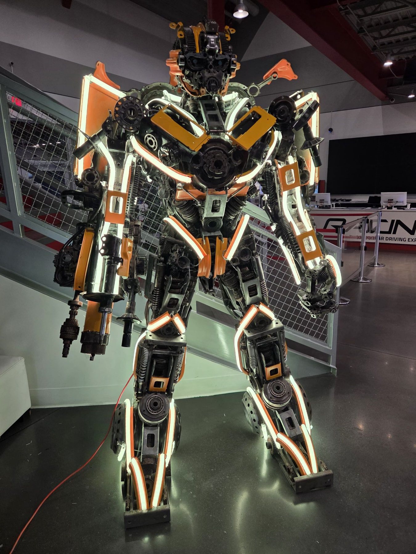 Scrap-metal robot sculpture with its LED neon set to warm white