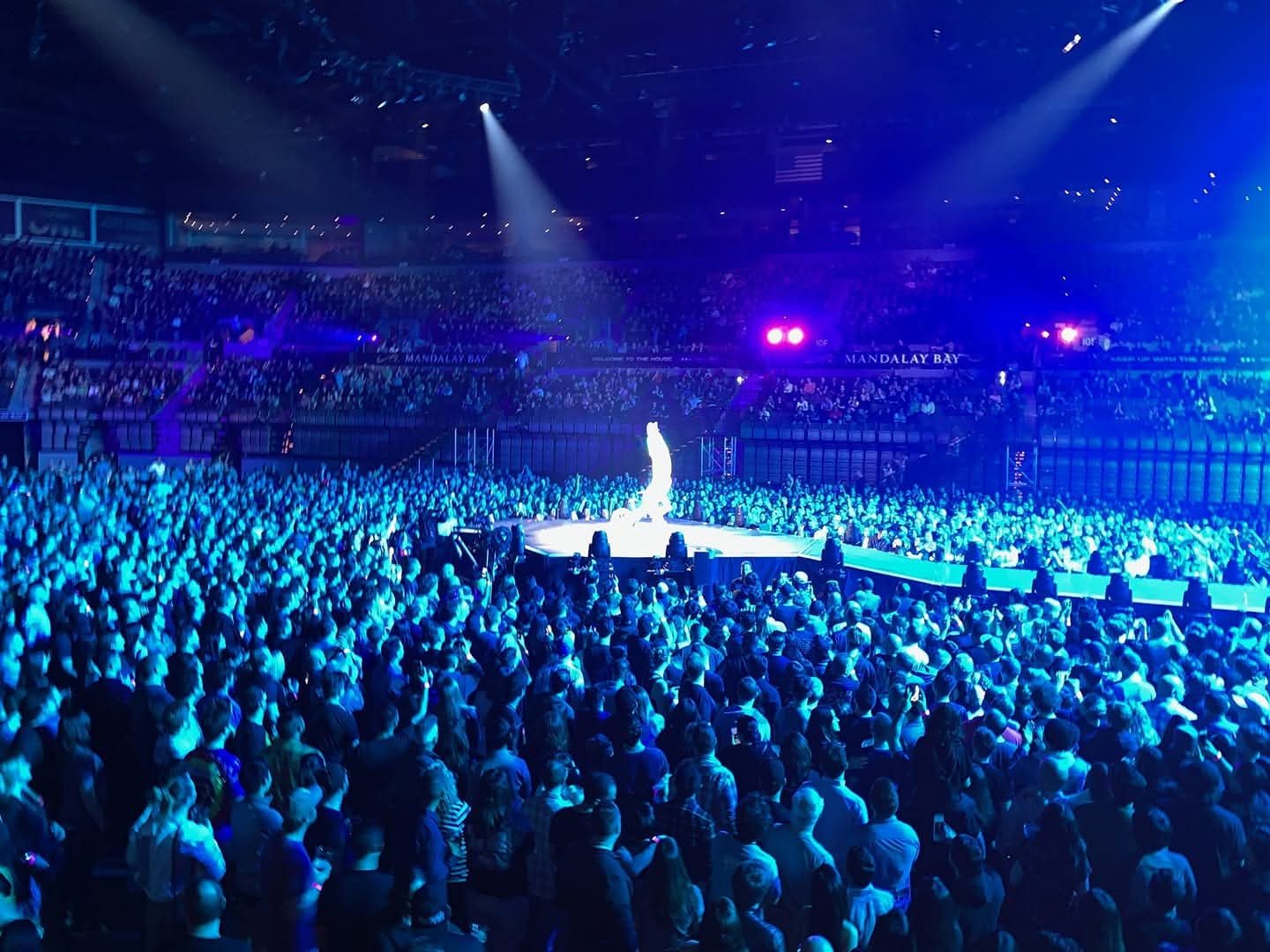 Blake Hicks performing on the LED bike on a lit stage in a packed Mandalay Bay arena during a Muse concert