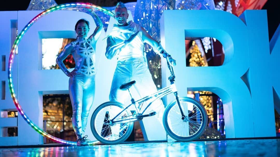 Blake Hicks and an LED hoop performer in front of giant letters at The Park, Las Vegas